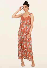 Maxi-jurk in roestoranje met bloemenpatroon. Getextureerde stof, brede bandjes en kantdetails. Vloeiende vorm, enkel-lange ontwerp.