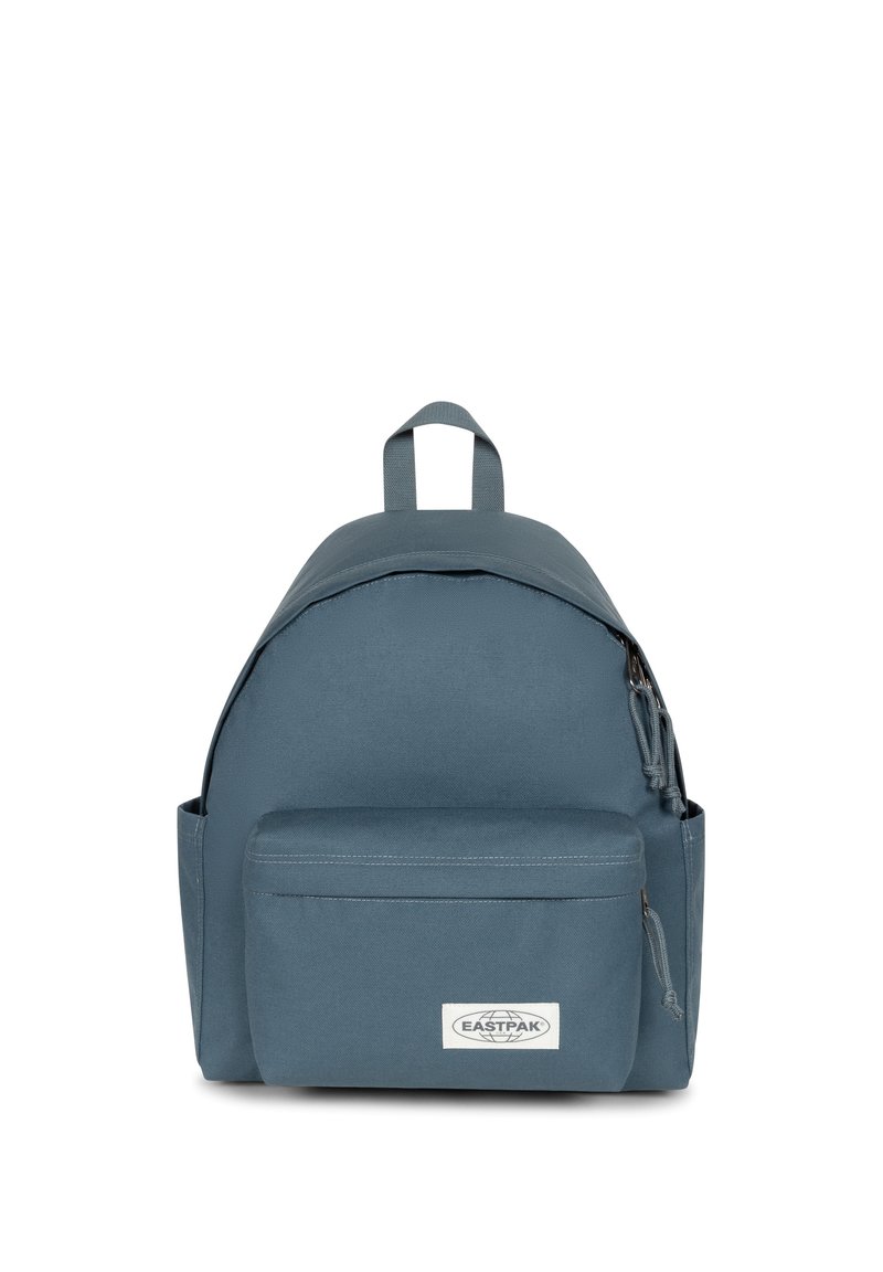 Blå tygryggsäck med rundad form, framficka med dragkedja, handtag upptill och logopatch på nedre fronten. Slitstarka material.