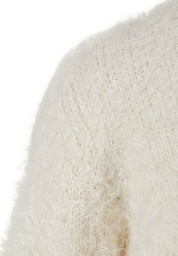 White sweater with a fluffy texture and loose knit pattern. Soft, lightweight material with subtle sheen and rounded shoulder detail.