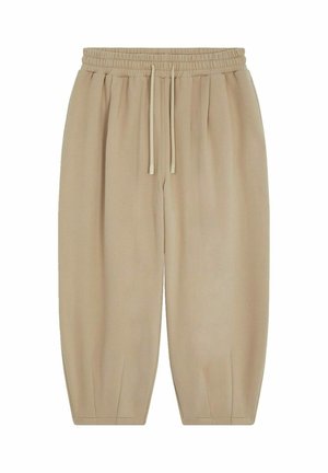 Pantalons beiges avec une taille élastique et des cordons de serrage, présentant des poches latérales et des jambes fuselées avec une texture lisse.