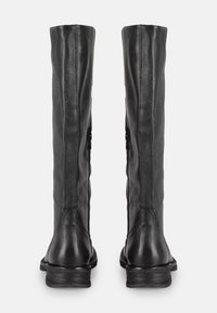 Bottes noires en cuir hautes avec une finition texturée, dotées d'une semelle plate, de deux zips latéraux et d'un design simple et élégant.