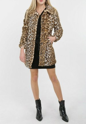Manteau en fausse fourrure imprimé léopard avec un col, des manches longues et deux poches latérales, associé à une robe noire et des bottines.