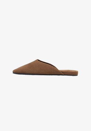 Zapato plano marrón de ante con puntera puntiaguda, sin cordones, tacón bajo y suela negra fina, mostrado de perfil sobre un fondo blanco.