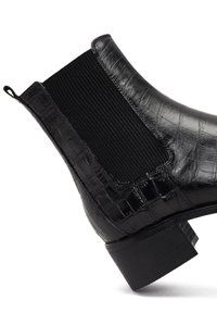 Botas negras hasta el tobillo con un acabado de piel con relieve de cocodrilo, paneles laterales elásticos y un tacón bajo apilado.