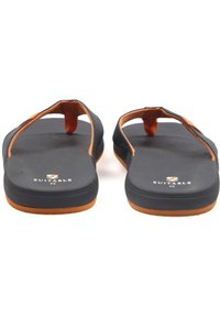 Zwarte flip-flops met oranje accenten, met een gestructureerde bovenband en een gladde voetbed. De zool is plat met een bruine onderkant.