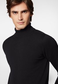 Czarny sweter z golfem, o prążkowanej strukturze, dopasowany krój z długimi rękawami, z wysokim kołnierzem.