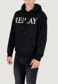 Sudadera negra de algodón con un gran logo blanco "REPLAY", bolsillo tipo canguro, puños acanalados y capucha con cordón.