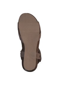 Brown sandal sole with textured rubber for grip, featuring a contoured shape. Buckle strap on the side for adjustable fit.
