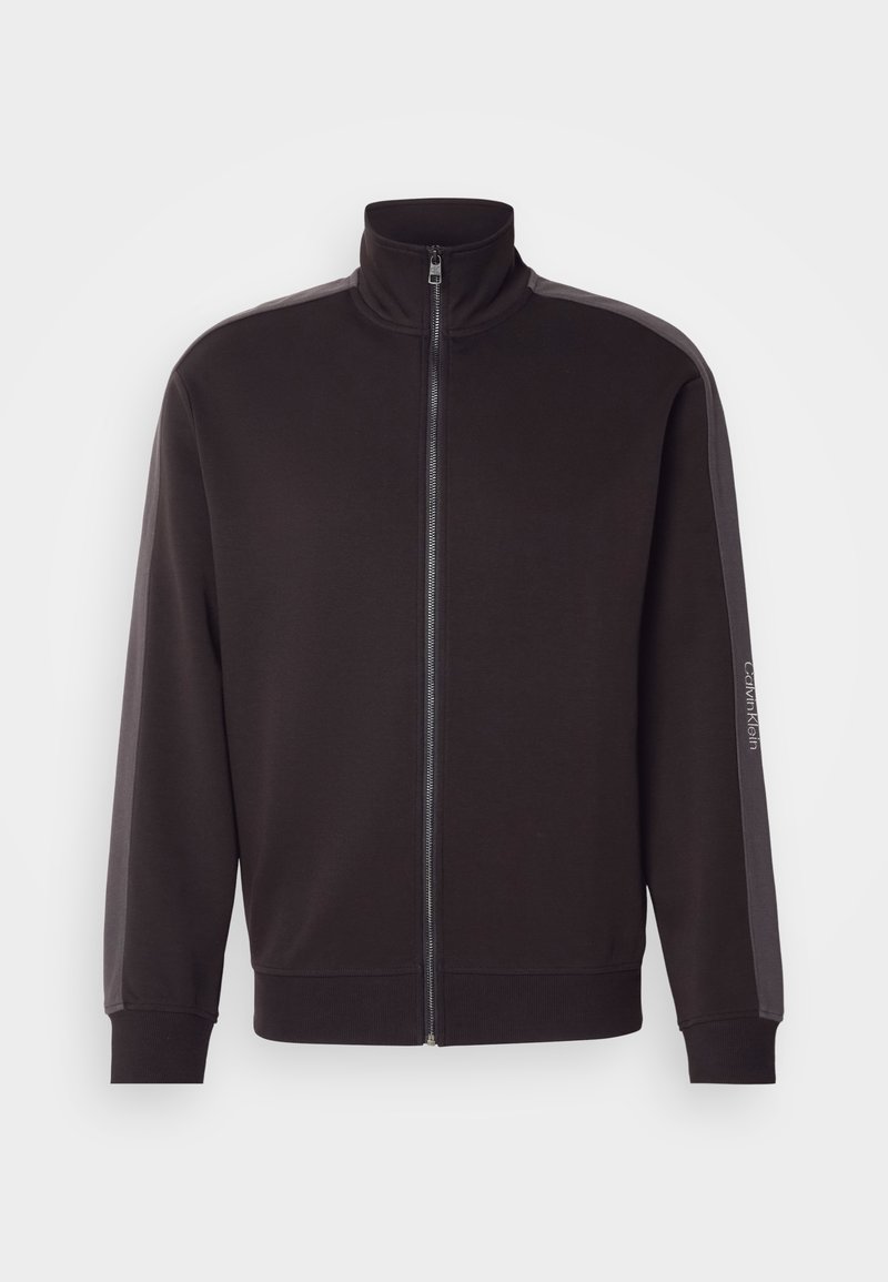 Felpa nera con zip e collo alto, realizzata in tessuto morbido. Presenta strisce grigie a contrasto lungo le spalle e polsini a coste.