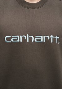 Hanorac maro cu logo alb brodat "carhartt" pe piept, având guler rotund.