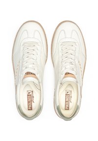 Baskets en cuir blanc avec accents beiges, lacets texturés et un talon vert clair. Présente des détails cousus et une semelle en caoutchouc.