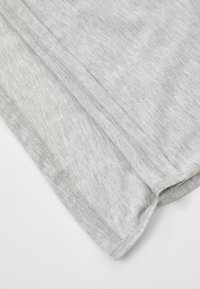 Szara bawełniana tkanina o miękkiej teksturze, z zaokrąglonym dołem i starannym przeszyciem. Brak widocznych wzorów lub elementów metalowych.