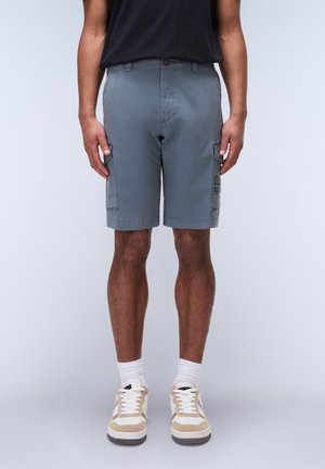 Gray cargo shorts with two side pockets, a button closure, and a straight cut. Worn with beige and white sneakers and white crew socks.