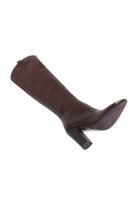 Botte en cuir marron, arrivant jusqu'au genou, avec un talon bloc, texture lisse, détails de couture arrondis et un discret tirant à l'arrière.