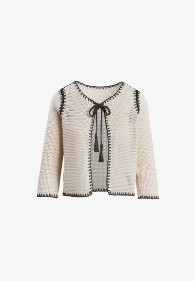 Krémový pletený cardigan s černým lemem, otevřeným předním zapínáním, rukávy po třičtvrtě a zavazováním s třásněmi. Texturovaný vzor po celém povrchu.