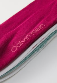 Κάλτσες Calvin Klein σε φουξία, λευκό και τιρκουάζ. Μαλακό πλεκτό ύφασμα με λεία υφή, με διακριτική κεντημένη λογότυπο στη φουξία κάλτσα.