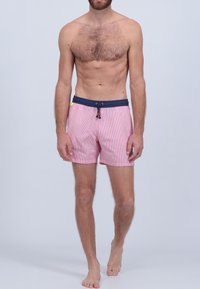 Shorts de bain rayés rouges et blancs avec une ceinture bleu marine, fermeture à cordon coulissant et poches latérales. Le matériau semble léger et respirant.