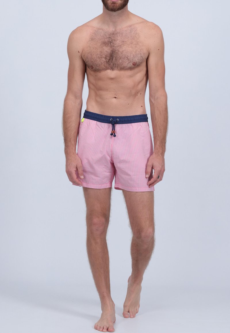 Shorts de bain rayés rouges et blancs avec une ceinture bleu marine, fermeture à cordon coulissant et poches latérales. Le matériau semble léger et respirant.