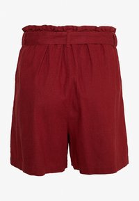 Pantalones cortos de lino rojos con cintura elástica, que presentan un borde superior con volantes y un diseño plisado. Estilo casual, holgado y de longitud a la rodilla.