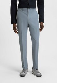 Light grey trousers with a smooth texture and tailored fit. Features a flat front, belt loops, and a subtle crease down the legs.