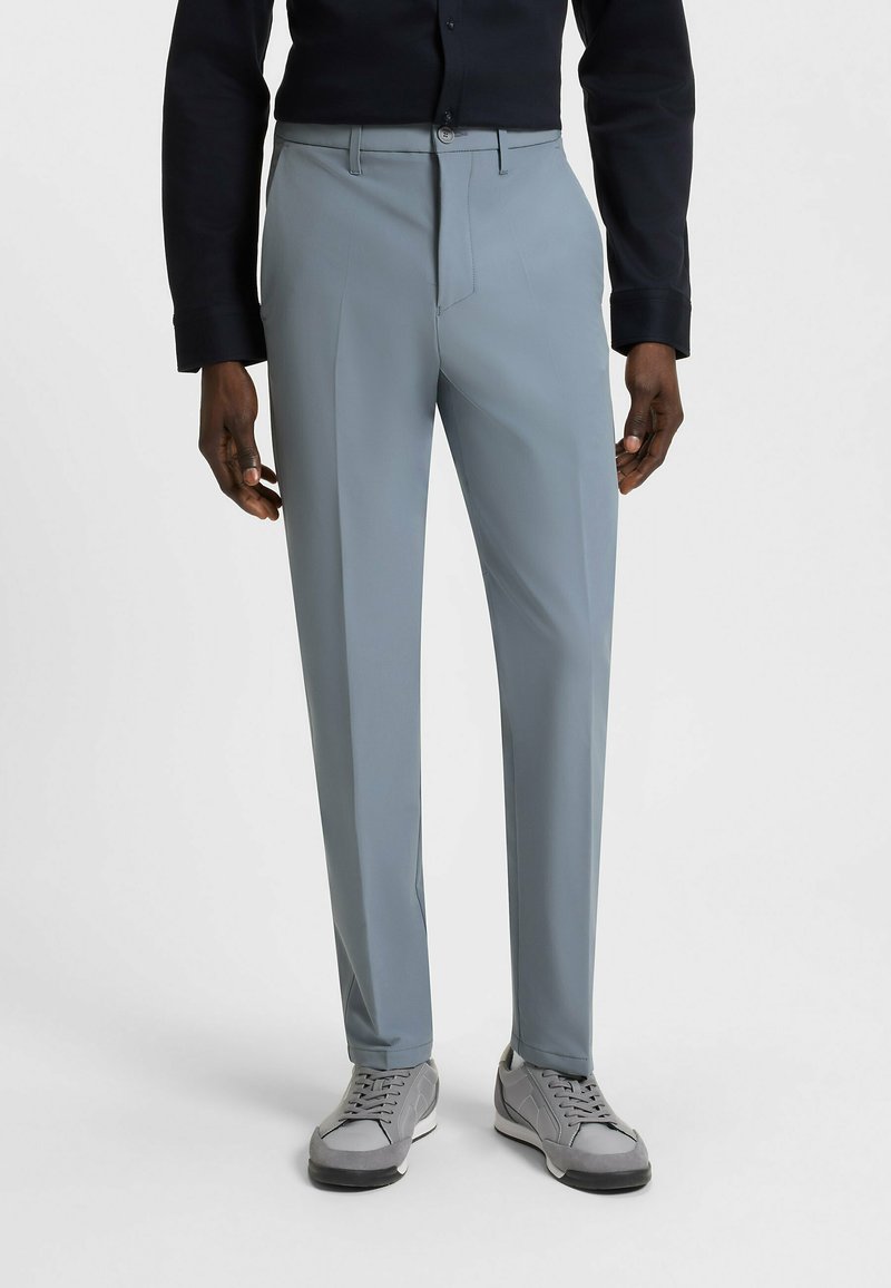 Light grey trousers with a smooth texture and tailored fit. Features a flat front, belt loops, and a subtle crease down the legs.