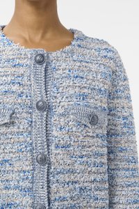 Blauwe en crème tweed gebreide jas van textuurstof, met vier opvallende zilveren knopen en twee borstzakken. De randen lijken rafelig.