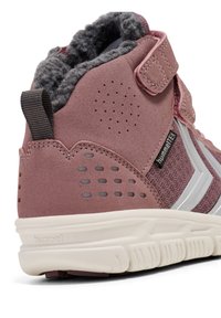 Lyserøde høje sneakers med en tekstureret ruskindsoverdel, grå fuzzy foring, velcrobånd og gummisål med ventilationshuller og sølvdetaljer.