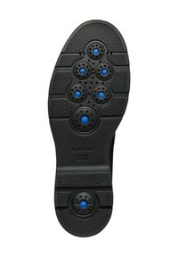 Suela de zapato de goma negra con agujeros de ventilación circulares en azul, patrones texturizados para agarre y detalle del logo.
