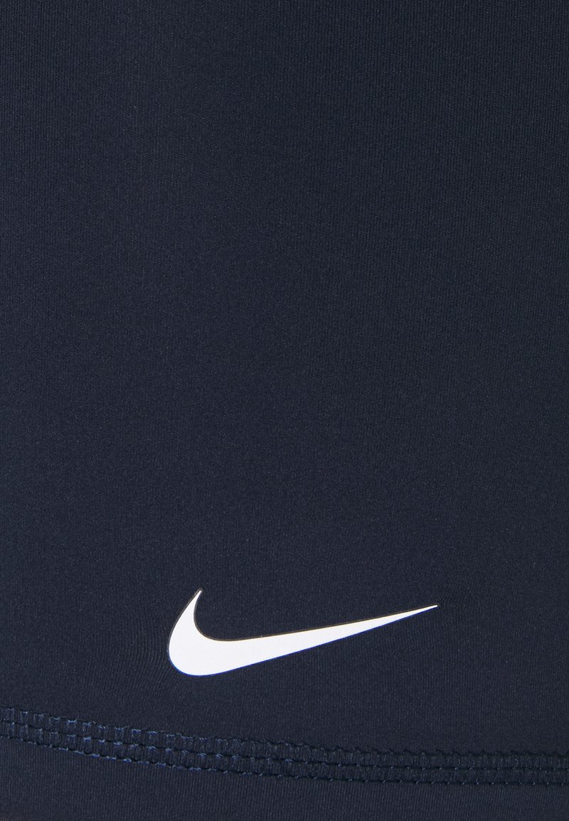 Pantalones cortos deportivos de color navy hechos de un tejido elástico, con un logo blanco de Nike en la parte inferior derecha y una costura plana en el borde inferior.
