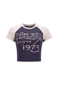 Camiseta corta de manga corta con un cuerpo azul marino y mangas raglán en crema, con un gran texto en crema que dice "DON ED HARDY designs 1973".