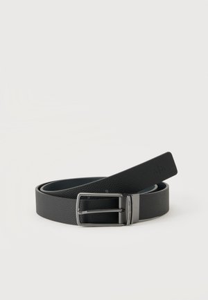 Cintura in pelle nera texturizzata con fibbia rettangolare in metallo argento e logo "A|X" impresso sulla fine, arrotolata su sfondo bianco.