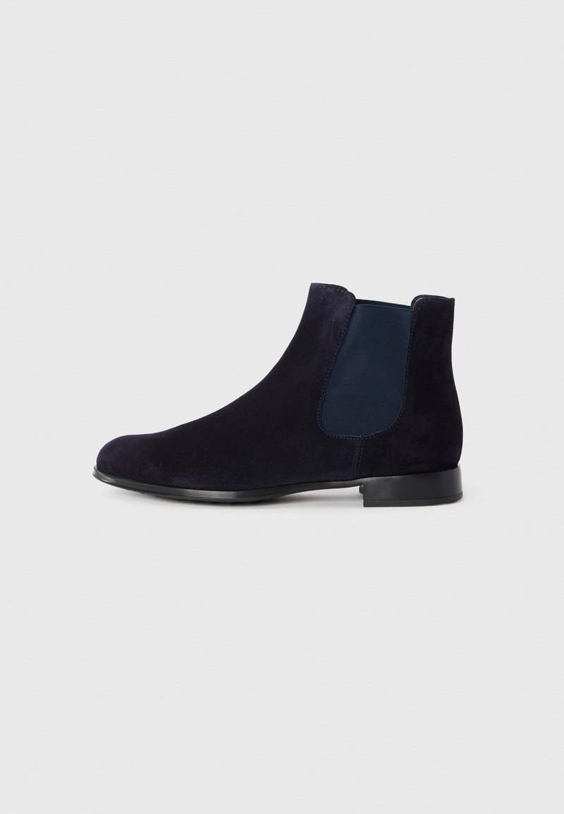 Botim Chelsea de camurça azul marinho com sola preta e painel lateral elástico, mostrado em perfil lateral esquerdo sobre um fundo claro simples.