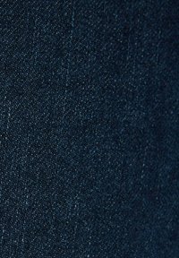 Tessuto in denim scuro con una superficie liscia, caratterizzato da una sottile tonalità di blu scuro e piccole macchie chiare intrecciate.