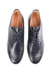 Scarpe in pelle blu navy con lacci, suola color crema e dettagli di cucitura. L'interno presenta un'etichetta "Fatto in Italia".