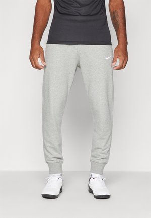 Gray cotton blend sweatpants with a tapered design, elastic cuffs, and a small white Nike logo on the left side. Worn with white sneakers.
