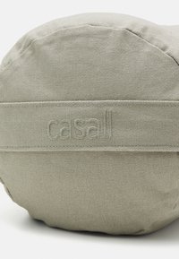 Apaļa pelēka auduma soma ar teksturētu virsmu un izšūtu logotipu. Apakša ir gluda, ar saskaņotu auduma joslu.