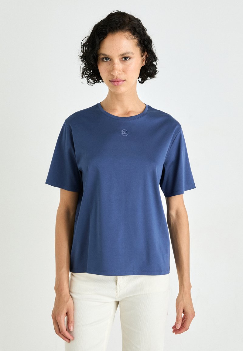 Korte mouwen crewneck t-shirt in marineblauwe stof. Voorzien van een subtiele logo op de borst en een relaxte pasvorm. Soepele, lichte textuur.