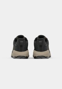 Black hiking shoes with a textured finish, featuring a tan sole, reinforced heel, and padded collar for support and comfort.
