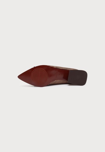Chaussure plate à bout pointu vue de la semelle, avec une semelle marron texturée et une tige à motif en maille.