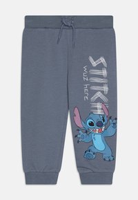 Heather-graue Sweatpants mit geripptem Bund, Zugband und Grafik des Stitch-Charakters mit dem Text "STITCH WUZ HERE" in Weiß.