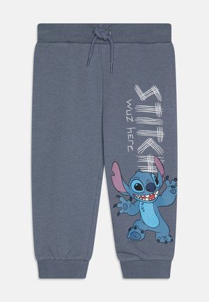 Sive sive hlače v svetle sivi barvi z rebrastim pasom, vrvico in grafiko lik Stitcha z besedilom "STITCH WUZ HERE" v belem.