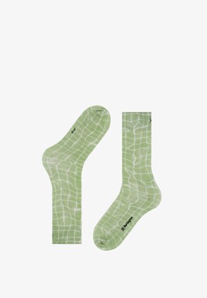 Chaussettes vert clair avec un motif quadrillé blanc, une chaussette à plat et l'autre légèrement pliée, montrant le logo de la marque près des orteils et de la cheville.