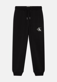 Melnas sporta bikses ar elastīgu jostu, auklu un ribotām aprocēm. Malā ir balts Calvin Klein logo. Gluda tekstūra.