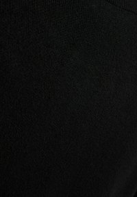 Schwarzer Strickstoff, weiche Textur, einheitliche Oberfläche mit subtilen Variationen. Glatte Oberfläche, leicht und geeignet für Freizeitkleidung.