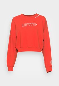 Felpa rossa corta in cotone, con una grafica bianca "LEVI'S" sul davanti e un'illustrazione del globo sulla manica sinistra.