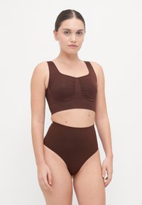 Brun to-delt svømmedrakt med en crop top med rynkedetaljer og høyt liv. Laget av glatt, elastisk materiale.