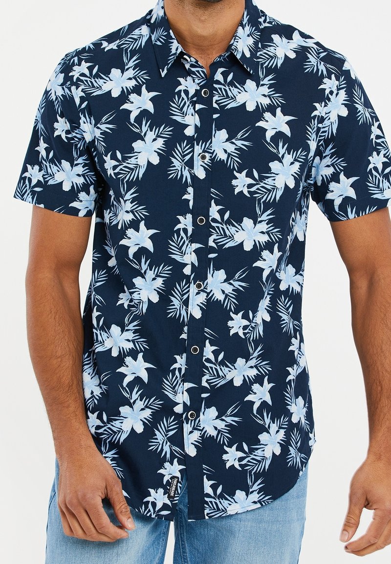 Chemise boutonnée marine à manches courtes avec motif floral bleu clair, en coton, dotée d'un col classique et d'un ourlet droit.