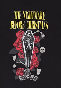 Maglietta nera con la scritta "Nightmare Before Christmas", una bara con Jack Skellington, rose rosse e decorazioni a forma di teschio.