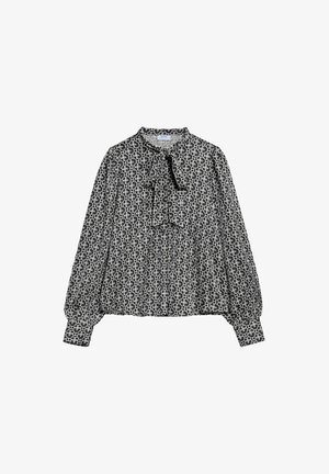 Czarna i biała bluzka w wzory z detalem w postaci łuku przy szyi, długimi bufkami i elastycznymi mankietami, wykonana z lekkiego materiału.