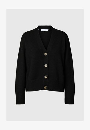 Mustvalge kardigan pehmest kangast, millel on V-kaelus, suur vorm ning neli suurt nööpi, ribatud alumine serv ja varrukad.